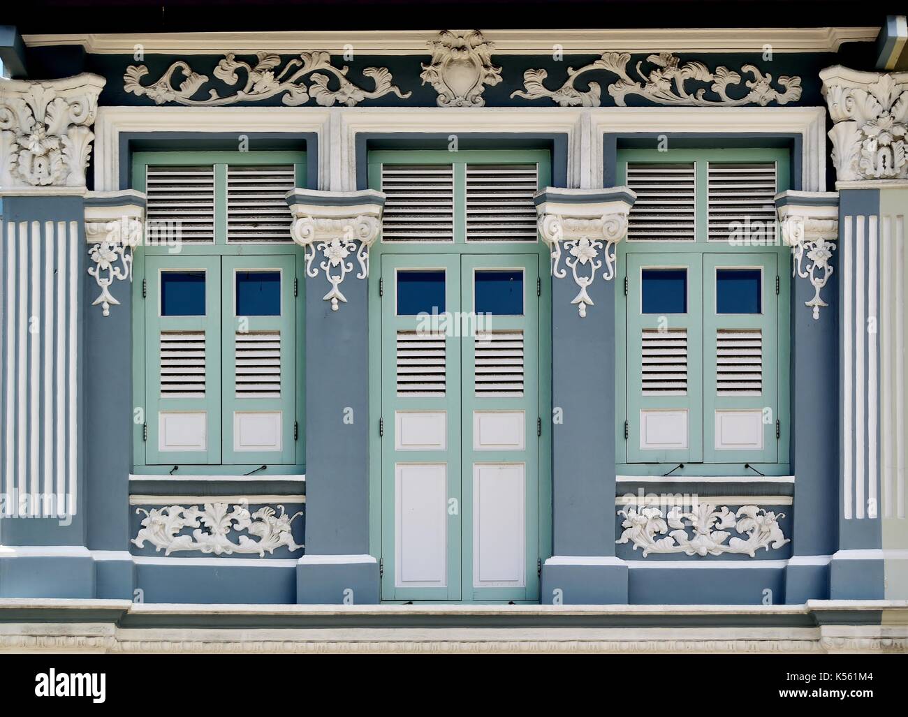 Traditionelle shop Haus außen mit grünen hölzerne Lamellenfensterläden und verzierten korinthischen Säulen im Joo Chiat District von Singapur Stockfoto