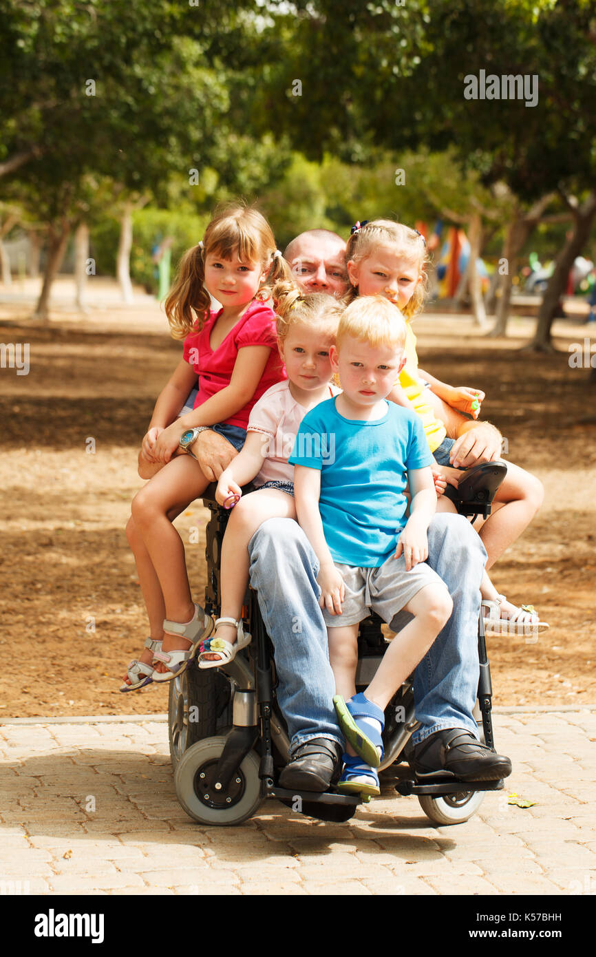 Behinderten Vater spielen mit seinem kleinen Sohn und drei Töchter Stockfoto
