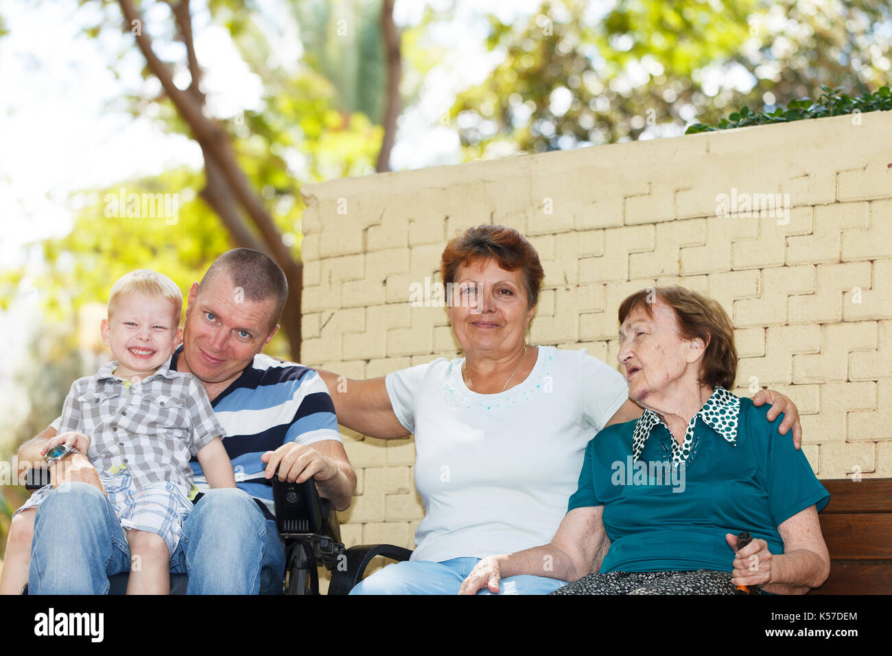 Vier Generationen der Familie sitzen zusammen im Park Stockfoto