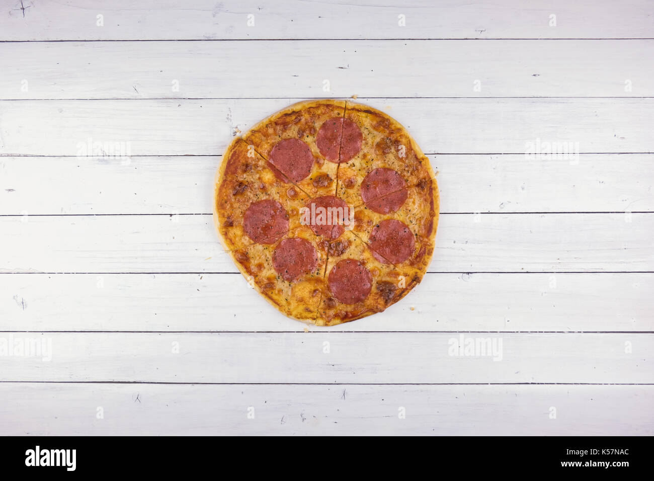 Blick von oben auf die Backen Pepperoni Pizza auf weißem Holz Hintergrund Stockfoto