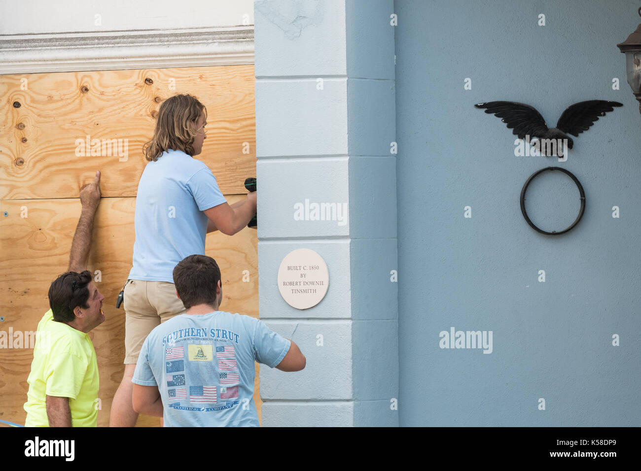 Arbeitnehmer sichern Sperrholz, die auf einem historischen Gebäude an der Broad Street in Vorbereitung für Hurrikan Irma September 8, 2017 in Charleston, South Carolina. Imra wird erwartet, die Charleston Bereich aber Hurrikan Vorbereitungen zu ersparen weiterhin als Irma einen Pfad der Zerstörung durch die Karibik verlässt. Stockfoto