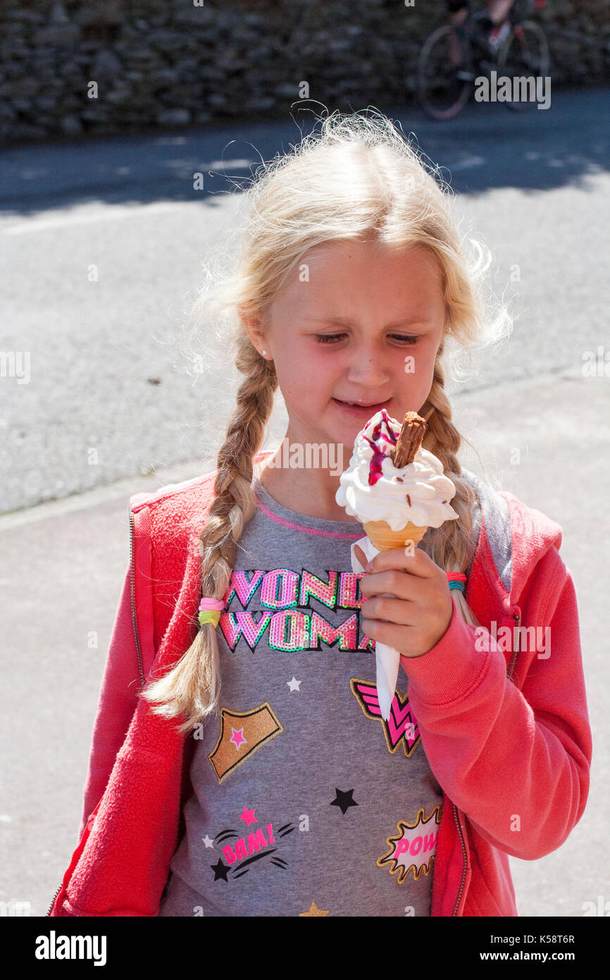 Mädchen essen Eis Kegel mit einem Schokolade flake in es an einem warmen Sommertag, Best Life Konzept, Glück, Freude, Glück, 99, sonnigen Tag Stockfoto