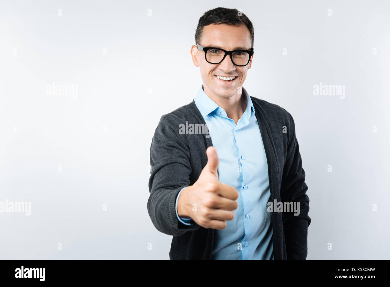 Freudige intelligenter Mann mit Daumen nach oben Geste Stockfoto