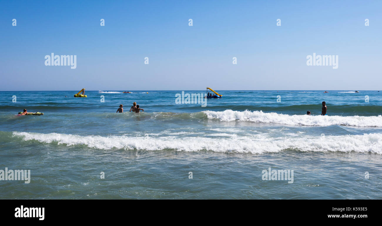 Marbella, Costa del Sol, Provinz Malaga, Andalusien, Südspanien. Playa Real de Zaragoza. Die Badegäste in den Wellen spielen. Stockfoto
