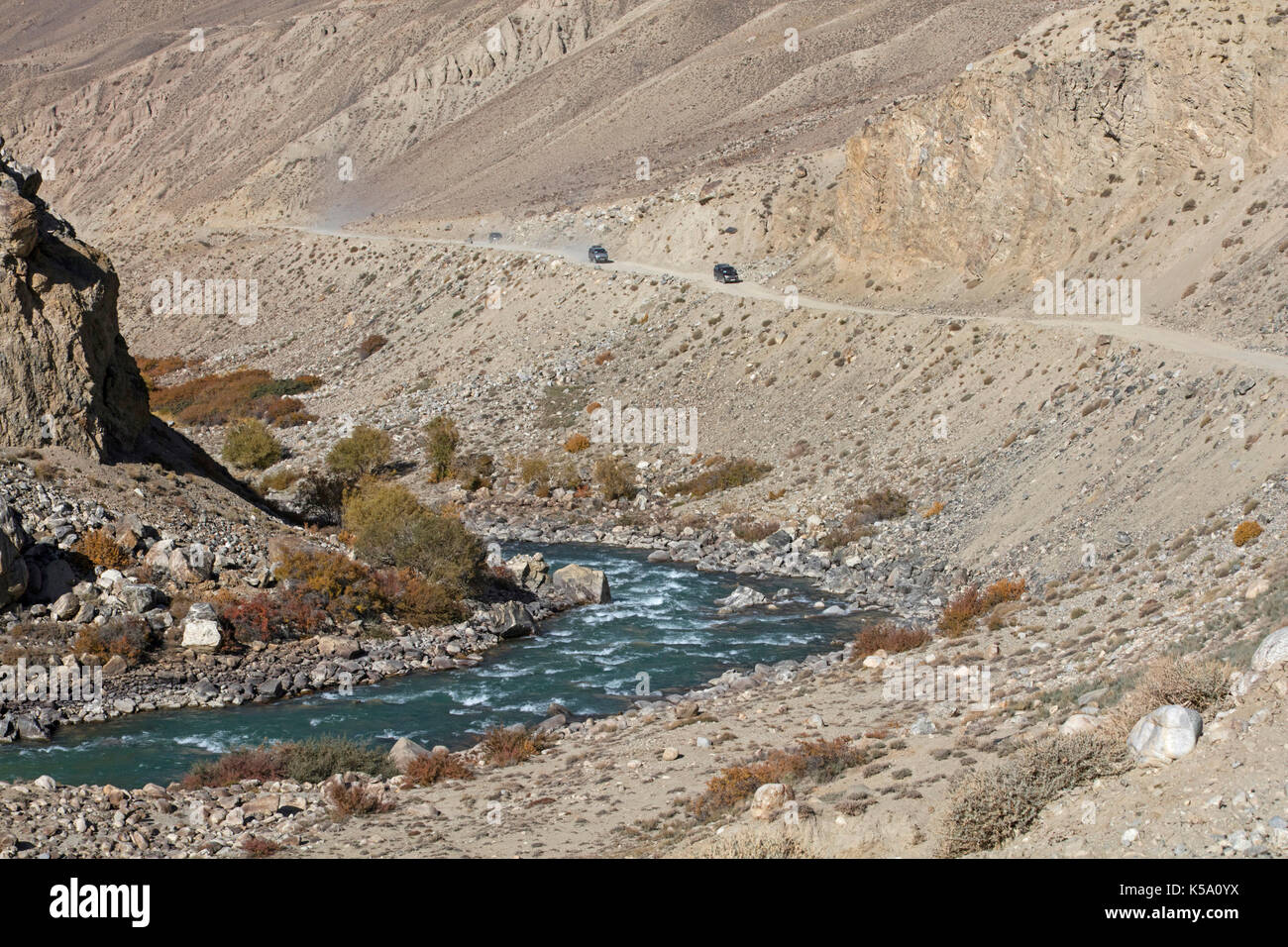 4WD Fahrzeuge fahren auf der Pamir Highway/M41 entlang der Pamir Fluss in der Provinz Gorno-Badakhshan, Tadschikistan Stockfoto