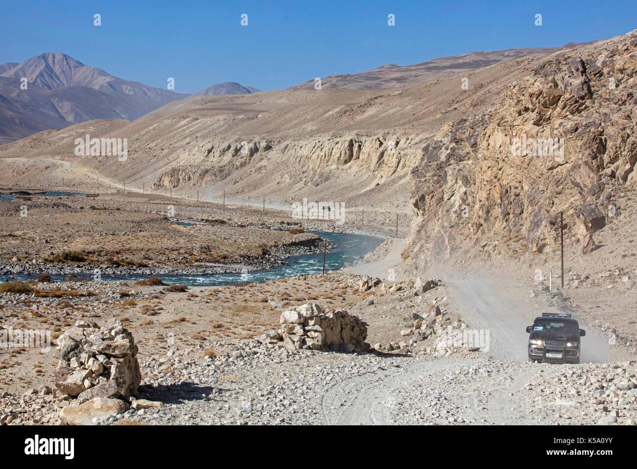4WD Fahrzeuge fahren auf der Pamir Highway/M41 entlang der Pamir Fluss in der Provinz Gorno-Badakhshan, Tadschikistan Stockfoto