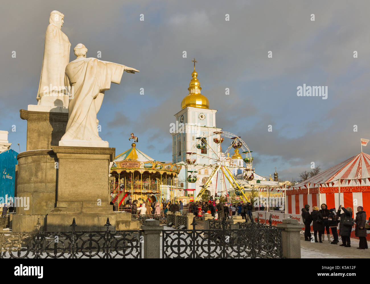 Kiew, Ukraine - Januar 03, 2017: die Menschen besuchen Weihnachten vintage Karussell und Riesenrad vor dem Denkmal der Prinzessin Olga und St. Michael Gol Stockfoto