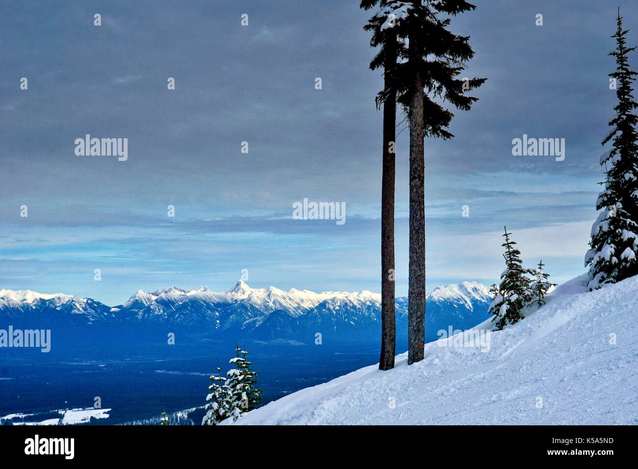 Landschaft auf Ski Hill mit steilen Hang und schneebedeckten Berg Hintergrund Stockfoto