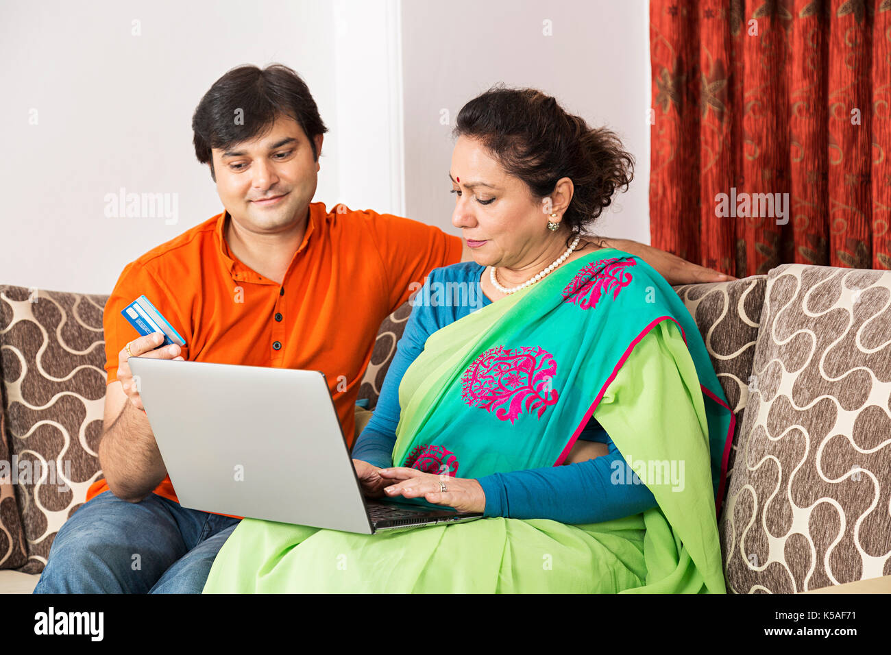 2 Personen erwachsener Sohn und Mutter Laptop Kreditkarte Online Shopping Stockfoto