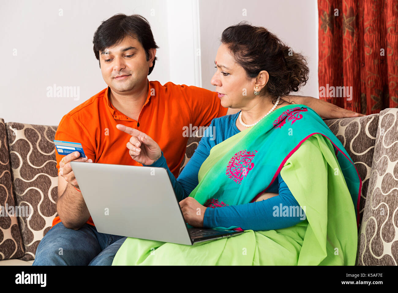 Indische Sohn und Mutter Laptop Kreditkarte, Online Shopping Stockfoto