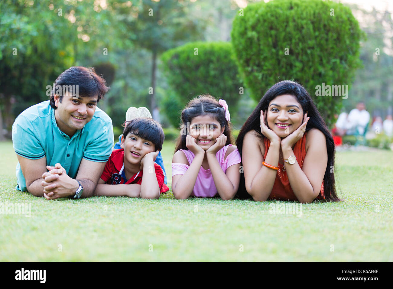 Happy indischen Familie Gras liegend entspannten Wochenende Urlaub genießen. Stockfoto