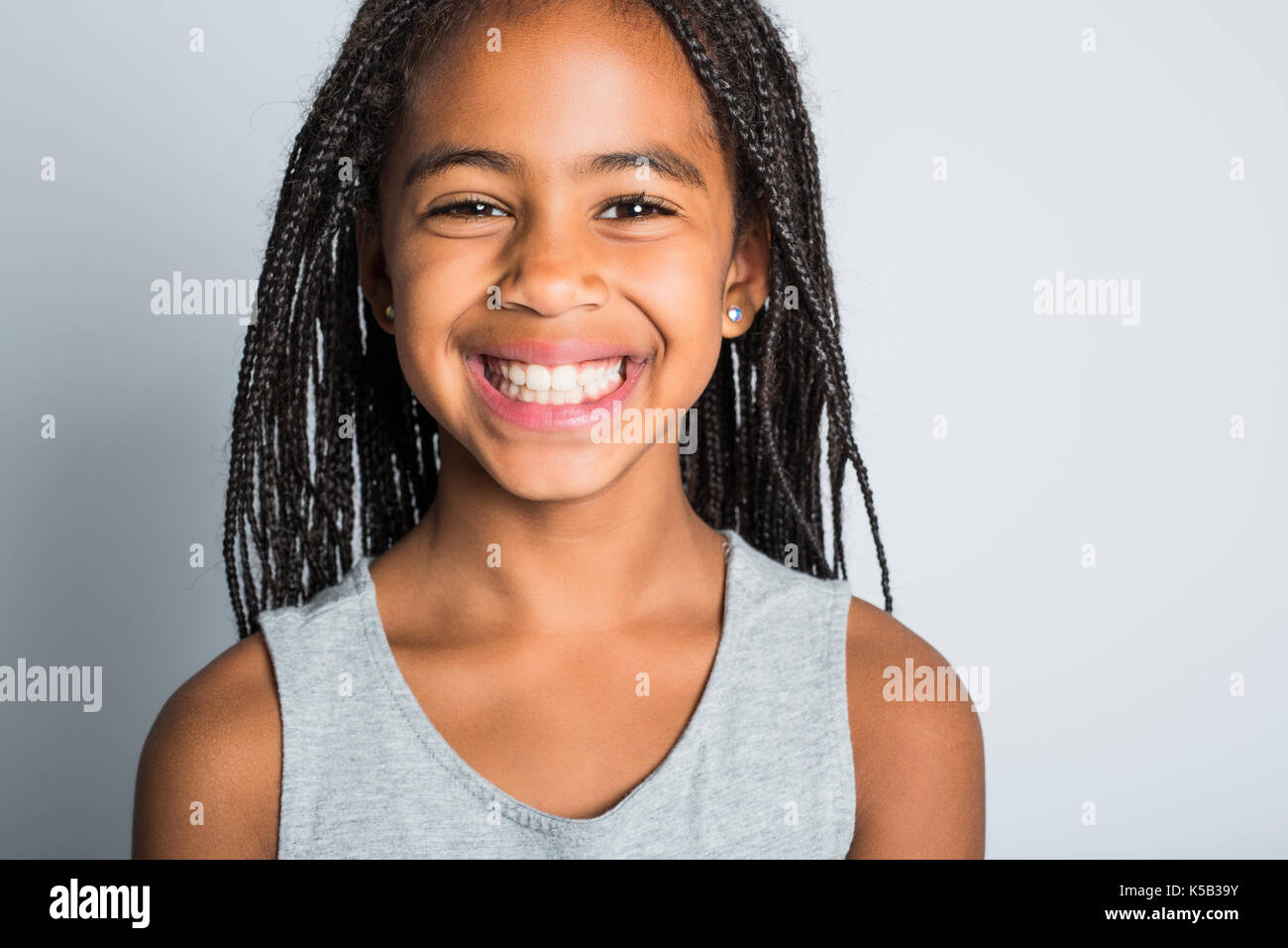 Adorable african kleines Mädchen in Studio grauer Hintergrund Stockfoto