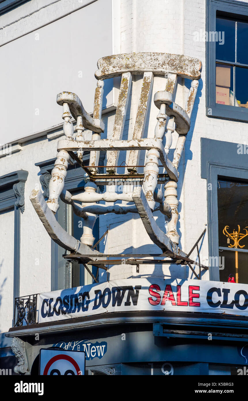 Eine große Schaukelstuhl auf der Fassade der alten und neuen Möbeln Store auf Chalk Farm Stange. Der Shop ist mit einer Schließung Verkauf. Stockfoto