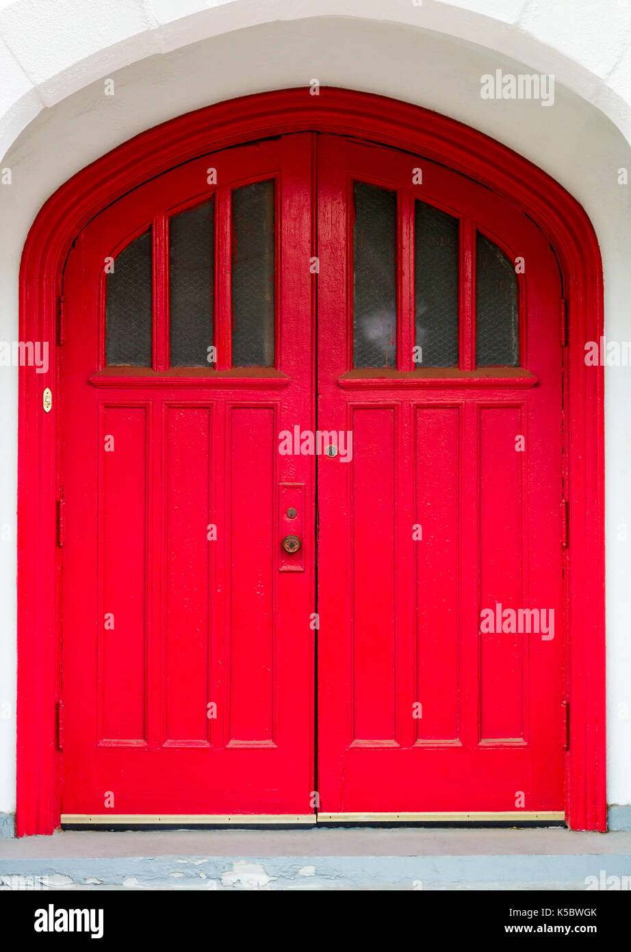 Leuchtend rote Türen zu einer Kirche Stockfoto
