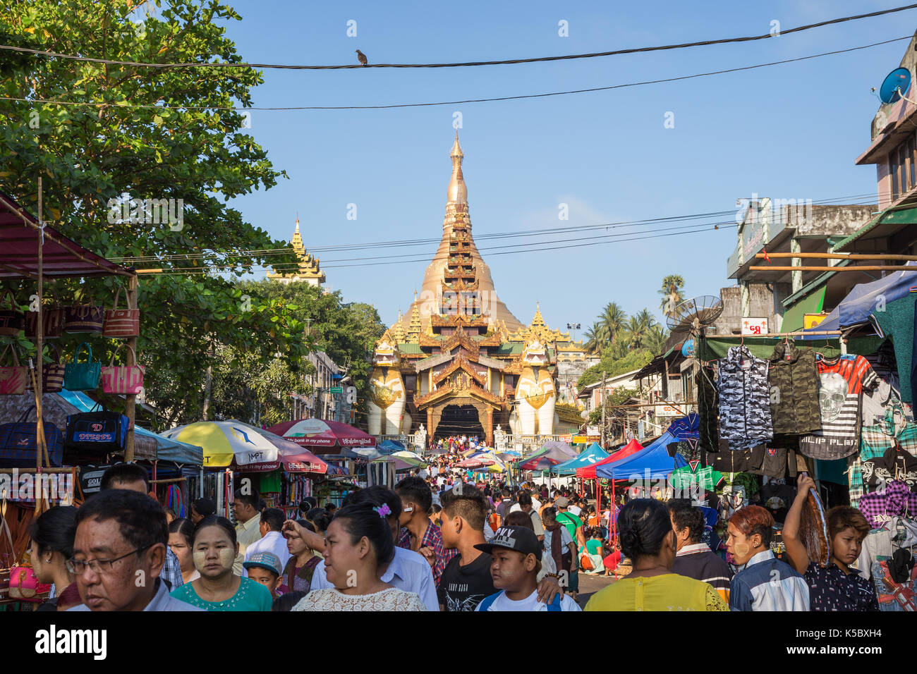 Die Shwedagon Pagode östlichen Eingang und eine Menge Leute auf einem Markt auf der Gyar Tawya Straße in Yangon, Myanmar. Stockfoto