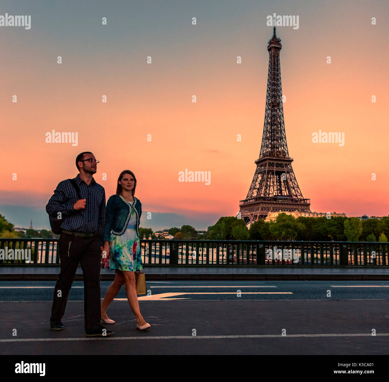 Junges Paar walking in Paris in der Nähe von Eiffelturm am Abend. Stockfoto