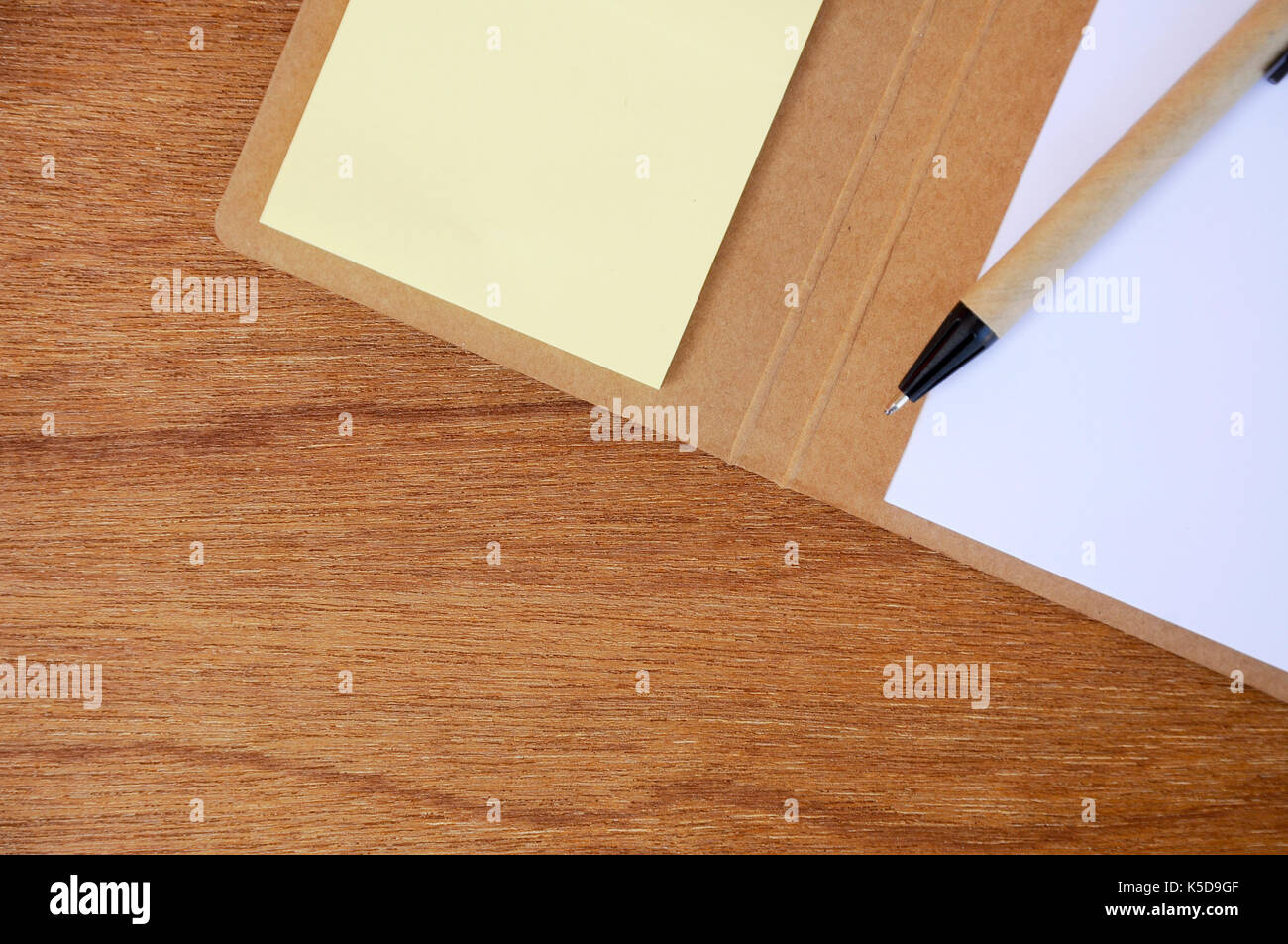 Braun pen, Notebook und bunte Zettel auf holzmaserung Hintergrund isoliert. Stockfoto