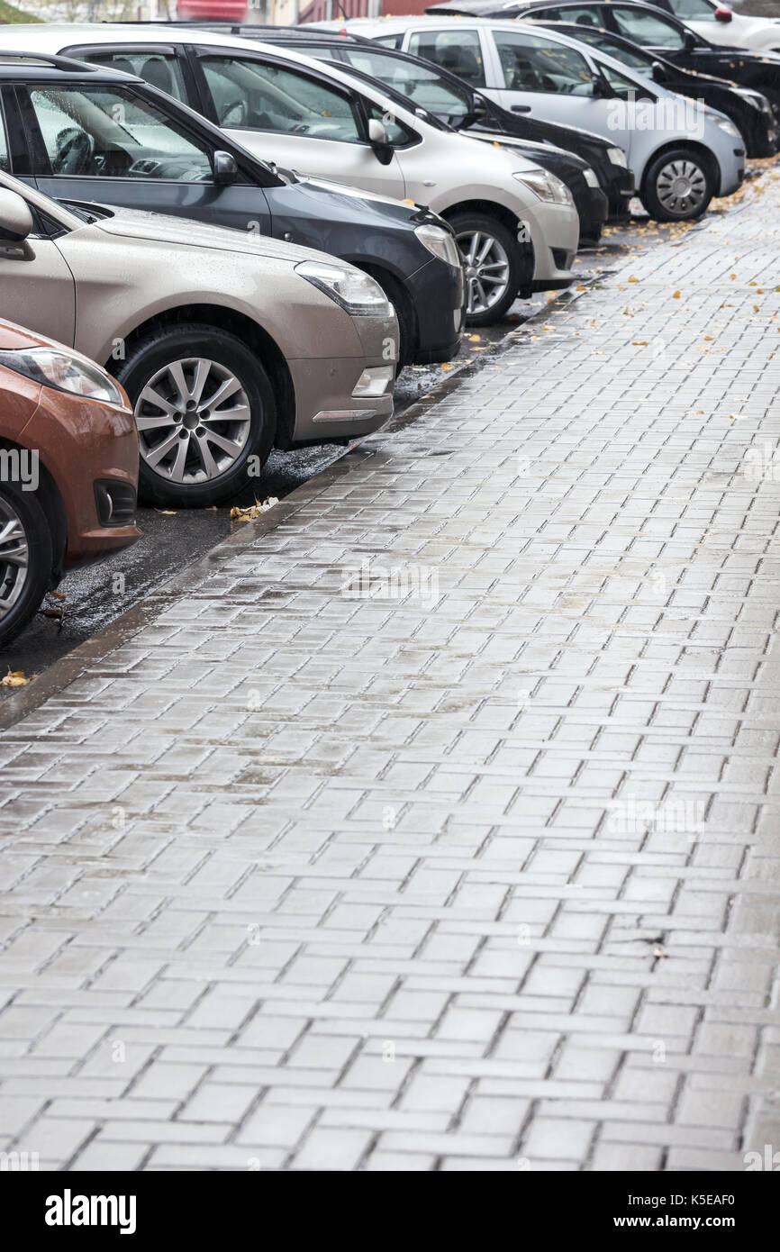 Viele Autos parken in der Stadt Straße an regnerischen Tag Stockfoto
