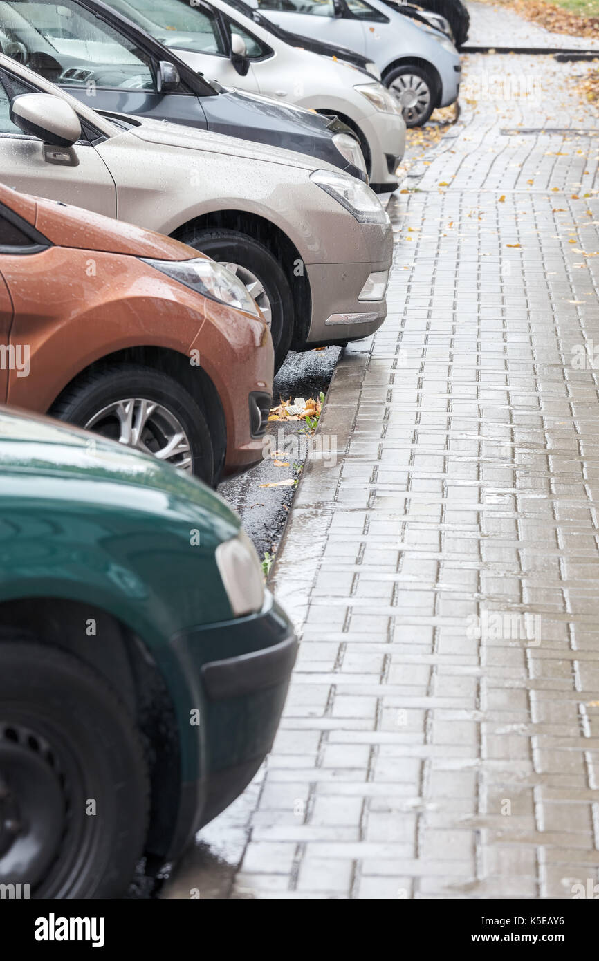 Reihe von Autos auf städtischen Parkplatz an regnerischen Tag Stockfoto