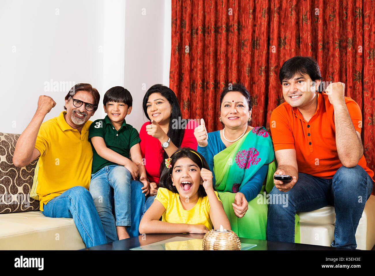 Happy multi Generation Familie watching Cricket Match auf Fernsehen im Wohnzimmer zu Hause Stockfoto