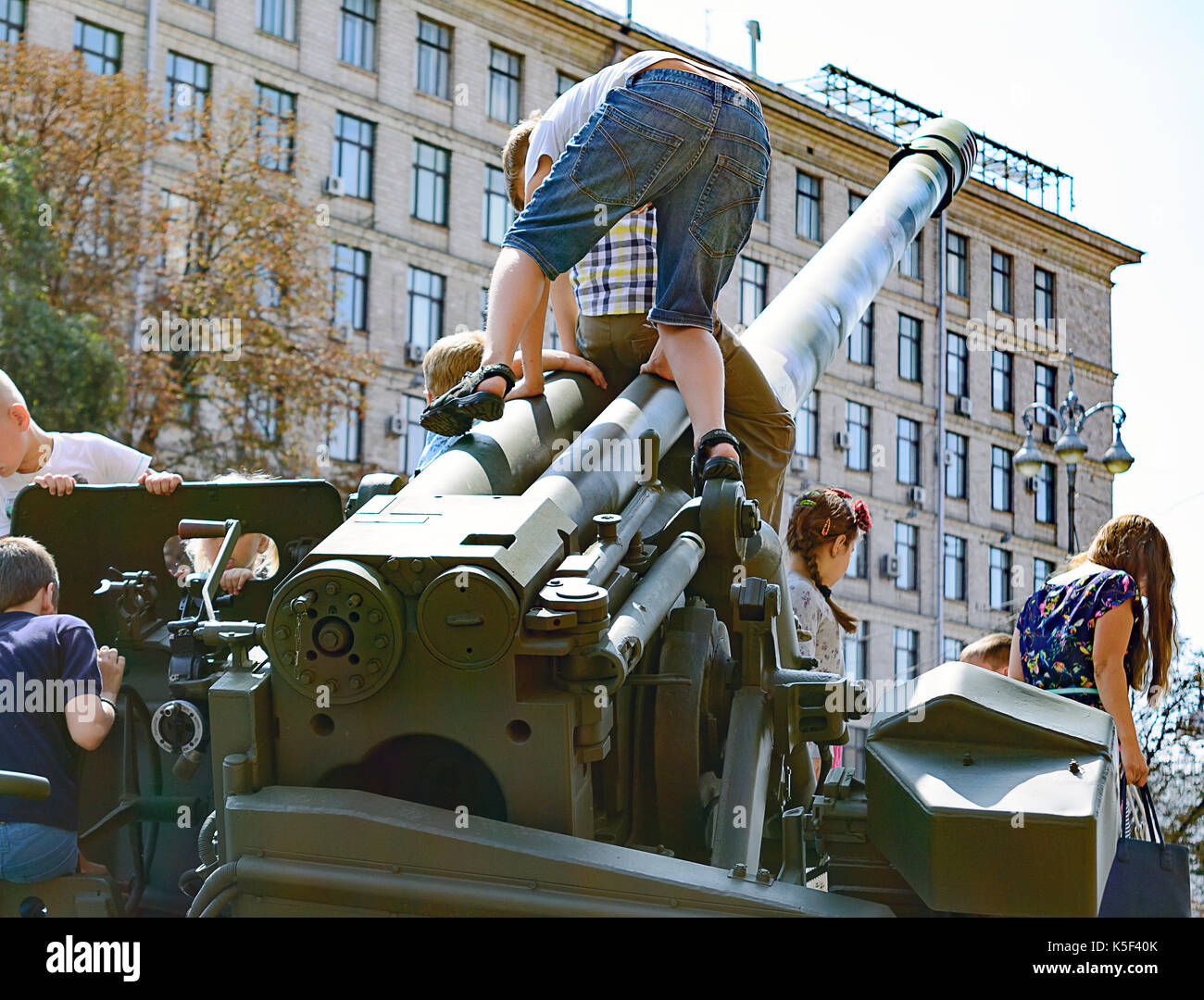 Kinder, die militärische Ausrüstung während der Ausstellung in Kiew spielen. September 23, 2017. Stockfoto