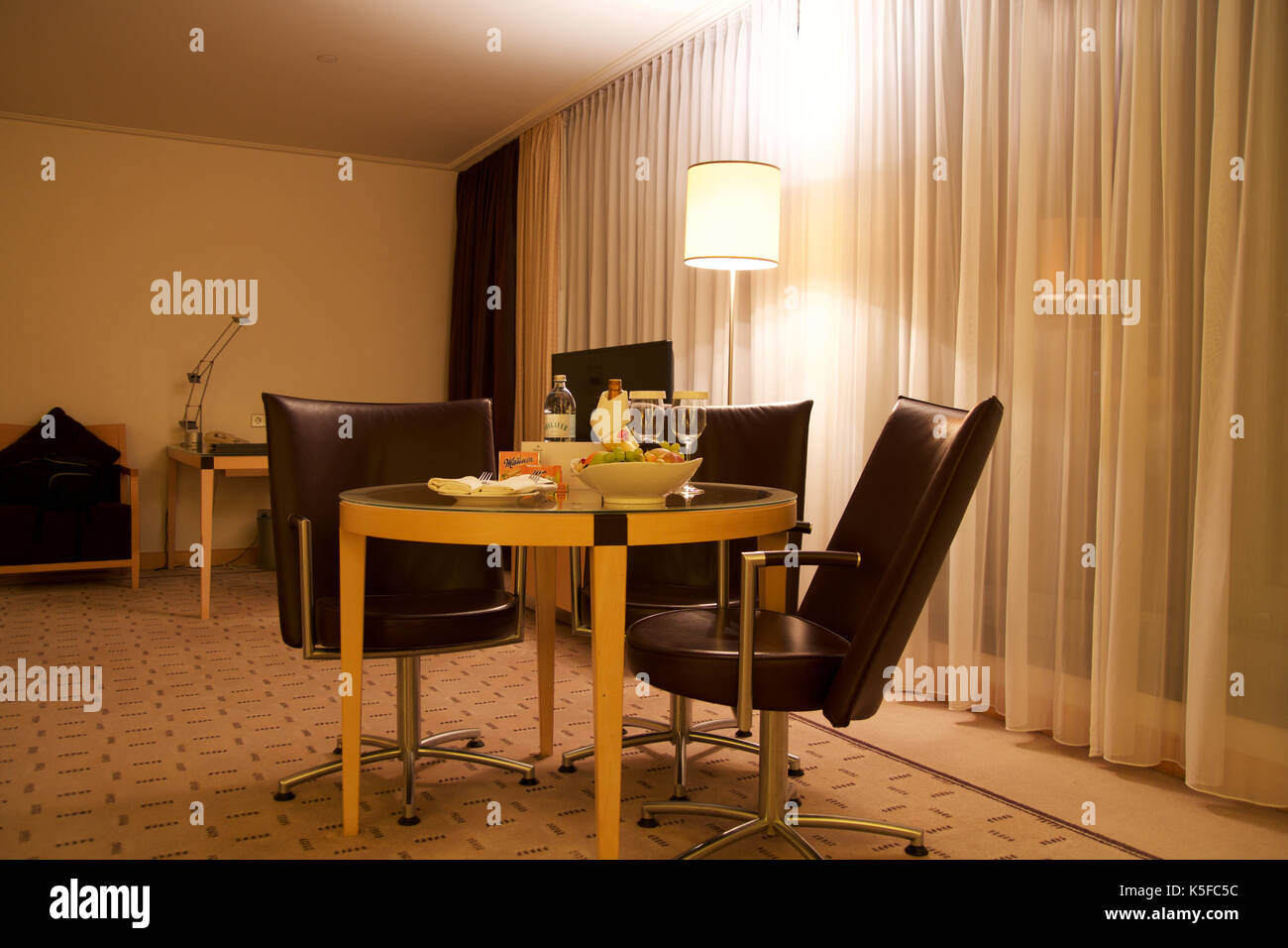 Wien, ÖSTERREICH - Apr 28th, 2017: Romantischer Abend mit einer Flasche Rotwein, Süßigkeiten und Früchte im Luxus Hotel Zimmer auf eine Tabelle mit 3 Lederstühlen, Hilton Penthouse Suite Stockfoto Wien, ÖSTERREICH - Apr 28th, 2017: Romantischer Abend mit einer Flasche Rotwein, Süßigkeiten und Früchte im Luxus Hotel Zimmer auf eine Tabelle mit 3 Lederstühlen, Hilton Penthouse Suite Stockfoto