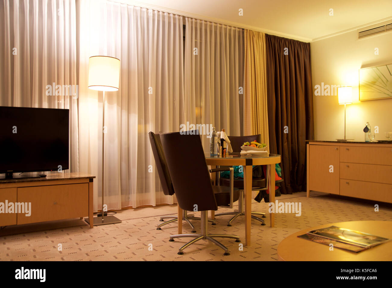 Wien, ÖSTERREICH - Apr 28th, 2017: Romantischer Abend mit einer Flasche Rotwein, Süßigkeiten und Früchte im Luxus Hotel Zimmer auf eine Tabelle mit 3 Lederstühlen, Hilton Penthouse Suite Stockfoto Wien, ÖSTERREICH - Apr 28th, 2017: Romantischer Abend mit einer Flasche Rotwein, Süßigkeiten und Früchte im Luxus Hotel Zimmer auf eine Tabelle mit 3 Lederstühlen, Hilton Penthouse Suite Stockfoto