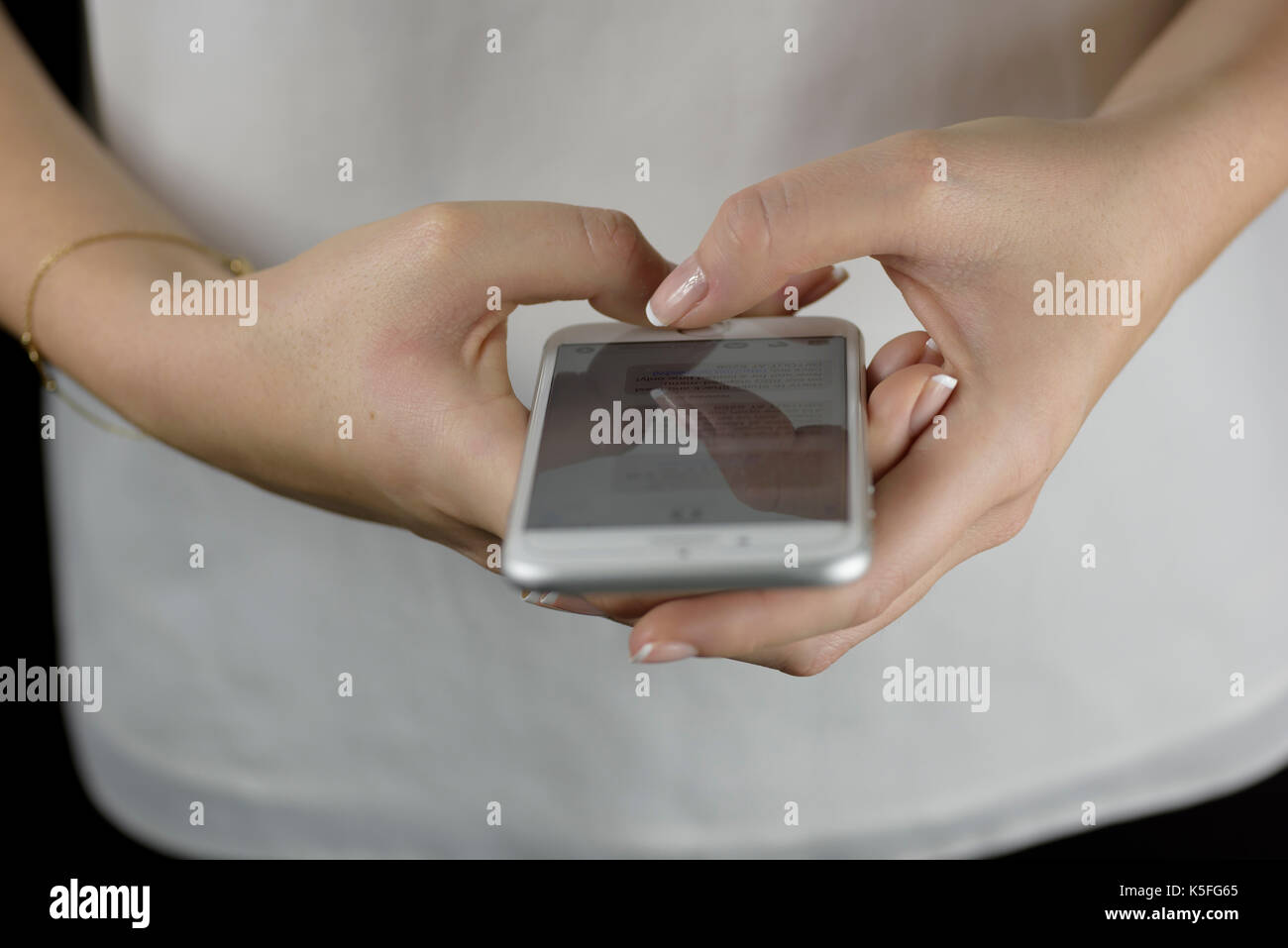 Nahaufnahme der Hände eines Mädchens, die Marketingbotschaften auf ihrem Smartphone lesen, Interaktion mit digitalen Angeboten, mobiles Marketing, Interaktion mit Werbeaktionen Stockfoto