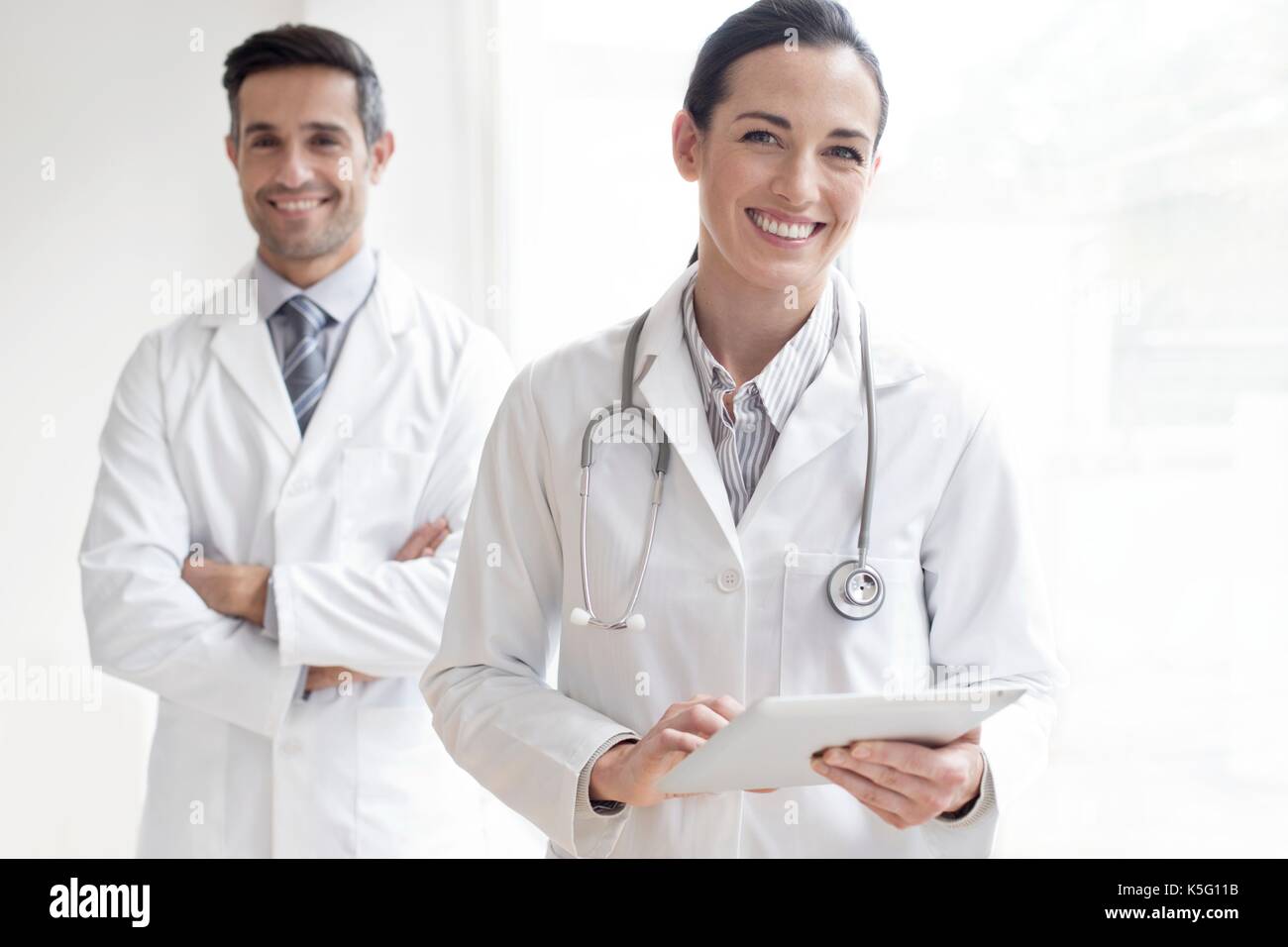 Frau Doktor mit männlichen Kollegen im Hintergrund, Portrait. Stockfoto