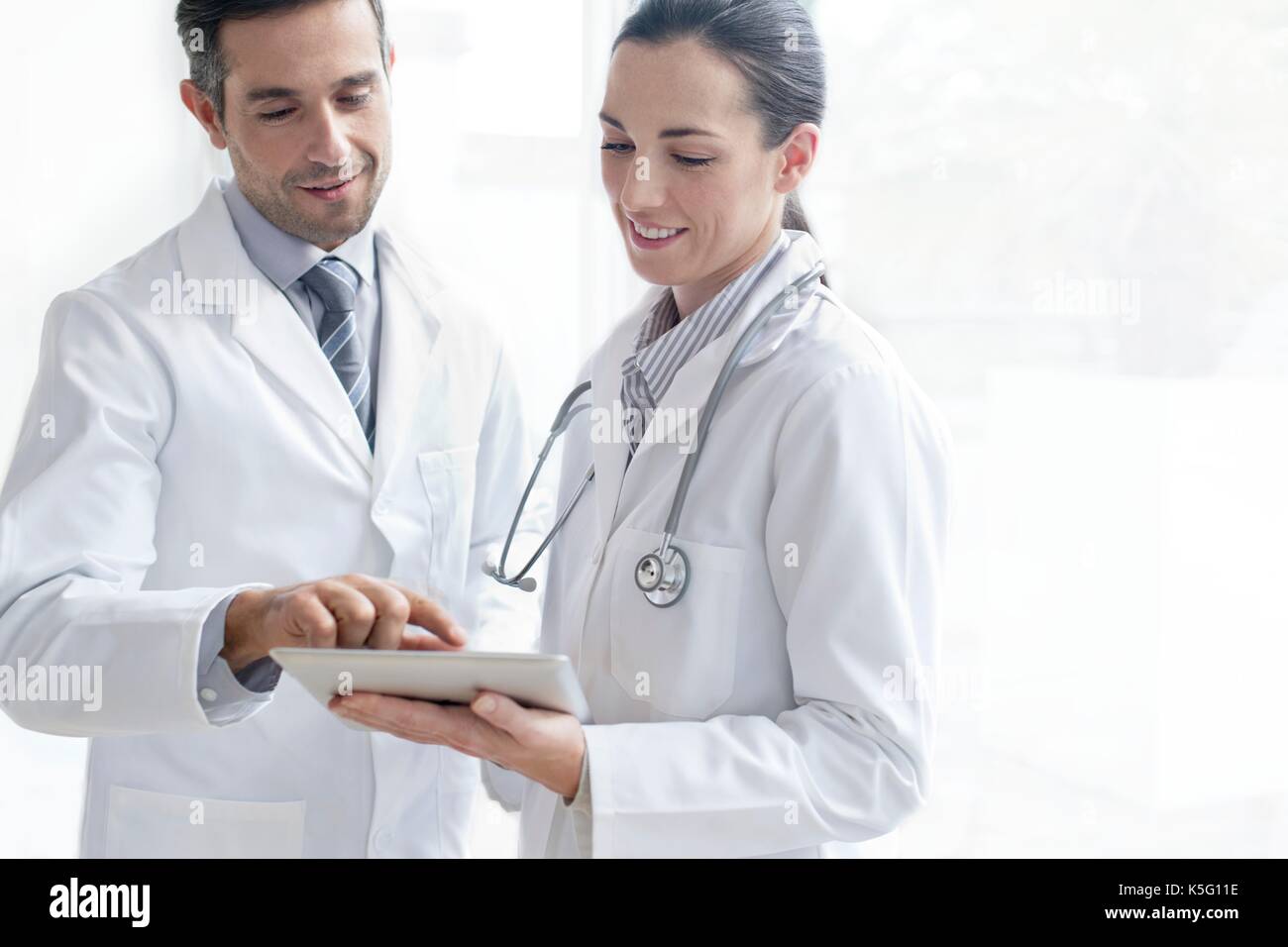 Männliche und weibliche Ärzte mit digitalen Tablet. Stockfoto