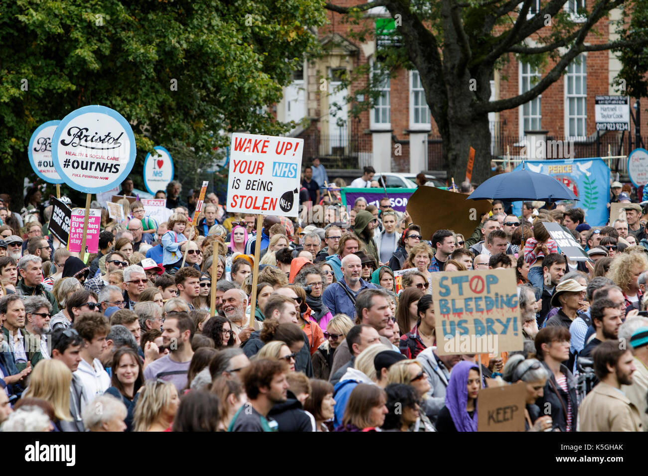 Bristol, Großbritannien, 9. September, 2017. Die Demonstranten Plakate tragen und fordert die Regierung, "die Kürzungen, die sie sagen, sind schädlich das Leben von so vielen abgebildet sind, da sie sich auf die Ausführungen in College Green, bevor Sie durch das Zentrum der Stadt in einem Anti bis März Sparmaßnahmen Protestmarsch und Kundgebung hören. Der Protest wurde für die von der Bristol Bürgermeister Marvin Rees genannt und wurde von der Bristol Labour Party unterstützt, die Grünen und über 30 Organisationen, einschließlich Gewerkschaften und Gruppen der Gemeinschaft verlangt, daß die konservative Regierung gibt Bristol und anderen Städten in Großbritannien die Finanzierung erforderlich Stockfoto