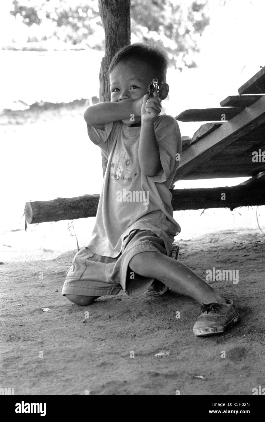 Karen burmesischen Flüchtlingskind Punkte eine Spielzeugpistole bei einem Camp im Nordwesten von Thailand. September, 1996. Stockfoto