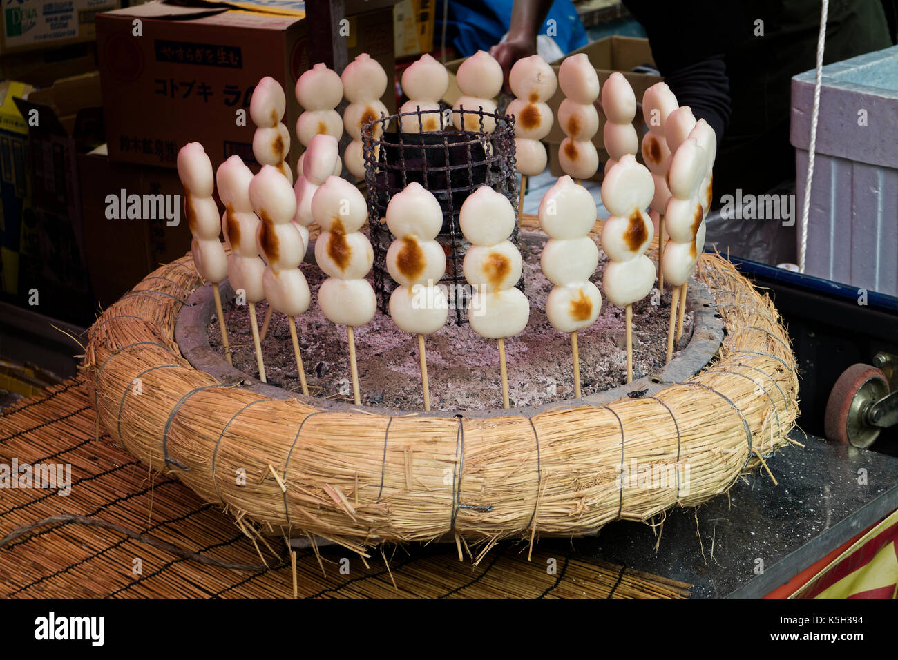 Tokio, Japan - Dango, ein japanischer Snack, drei klebrigen Reis kuchen Kugeln auf einem Spieß geröstet und in der Nähe eine Holzkohle Herd erwärmt Stockfoto