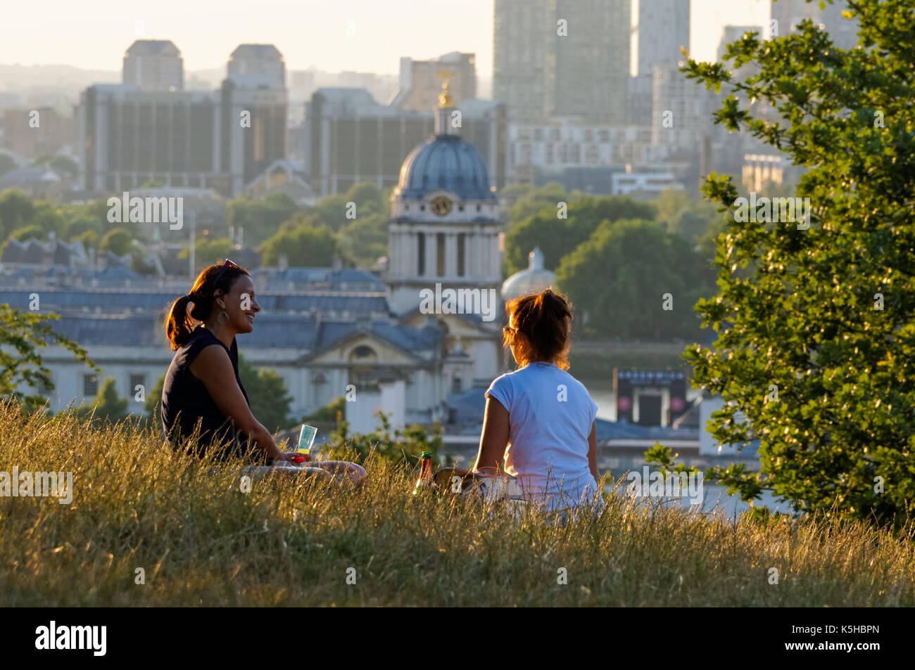 Zwei junge Frauen genießen sonnigen Tag im Greenwich Park in London, England, Vereinigtes Königreich, Großbritannien Stockfoto