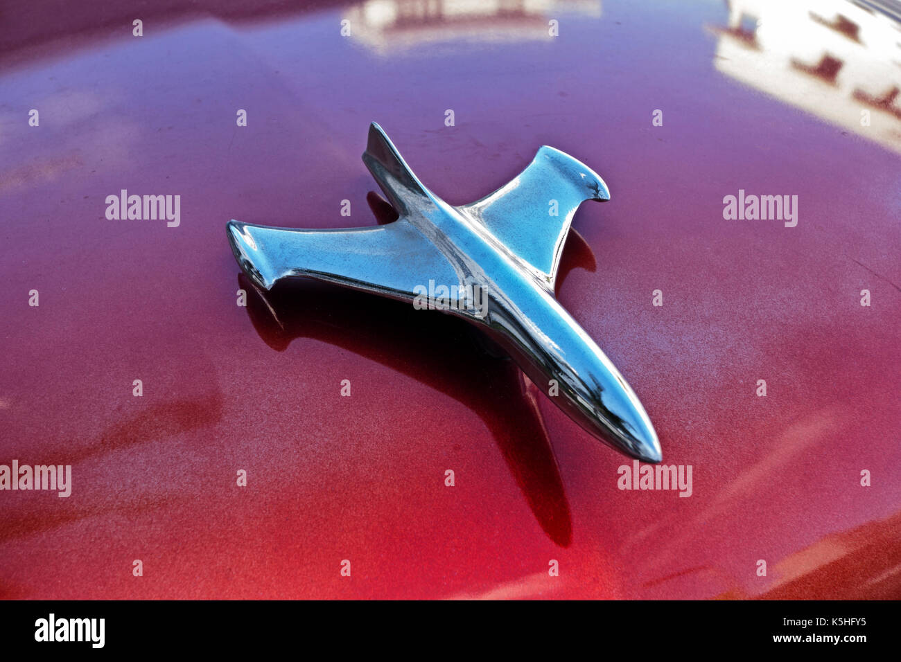 Eine verchromte Kühlerfigur ziert die leuchtend roten Lackierung auf der Vorderseite eines Vintage American Car in Miami Beach, Florida. Stockfoto