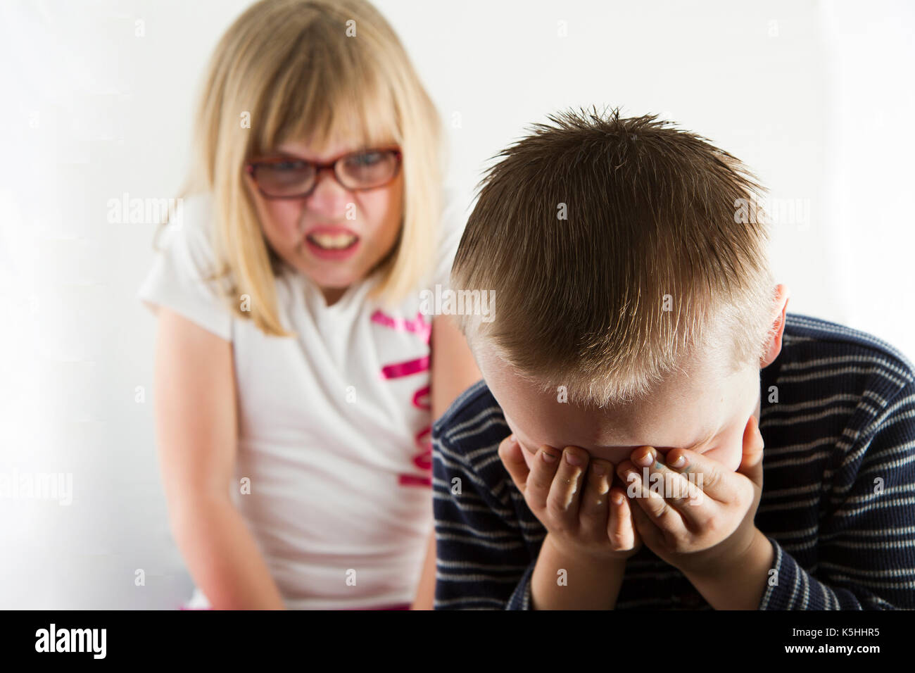 Junge traurig, wie er von einem wütenden Mädchen abgeholt wird. Stockfoto