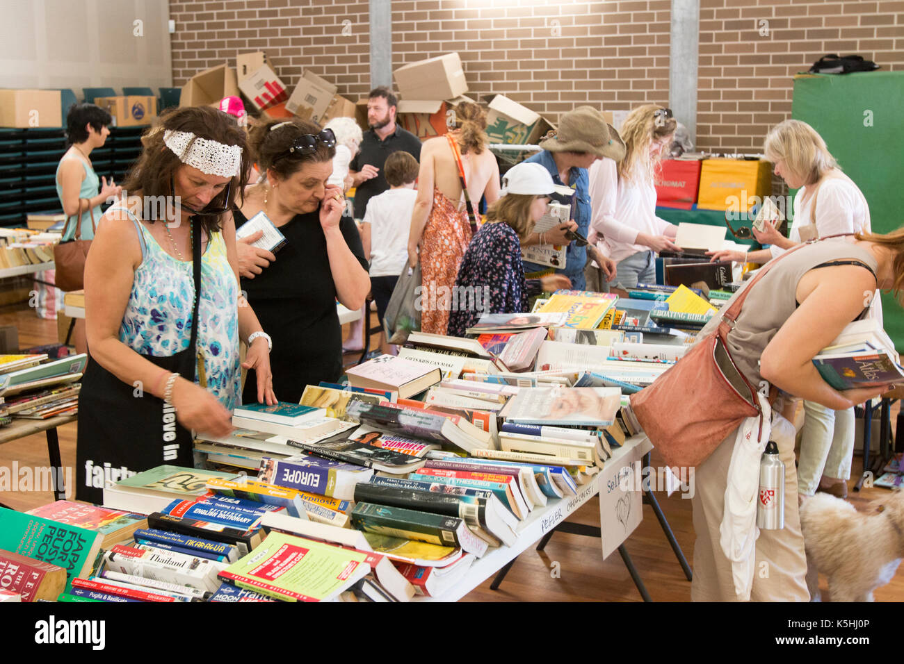 Damenschulmütter stöbern durch gebrauchte Bücher zum Verkauf auf einem australischen Grundschulfest in Sydney, New South Wales, Australien Stockfoto