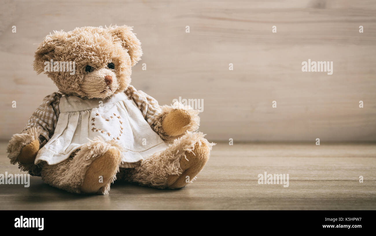 Teddybär sitzen auf einem hölzernen Hintergrund Stockfoto