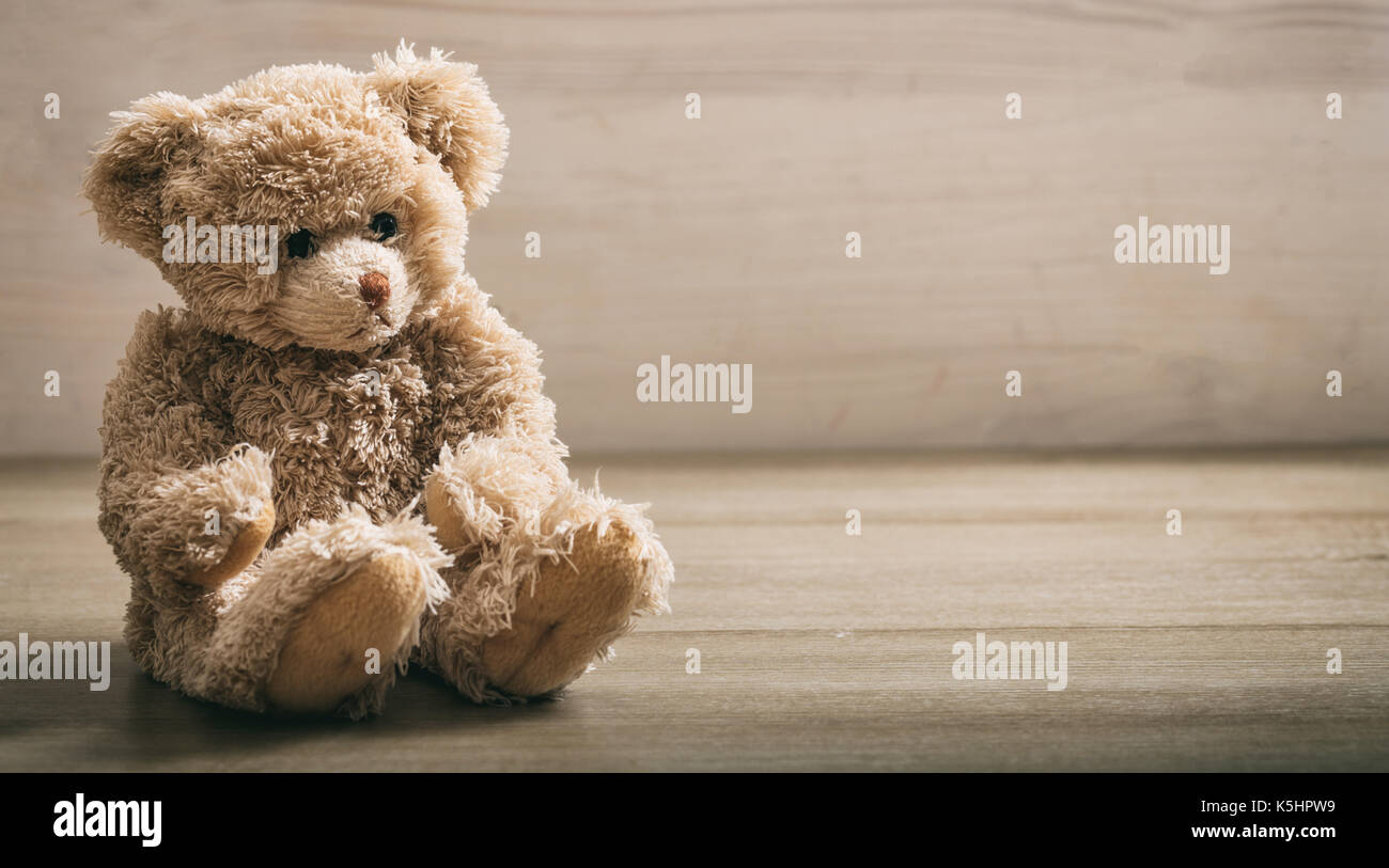 Teddybär sitzen auf einem hölzernen Hintergrund Stockfoto
