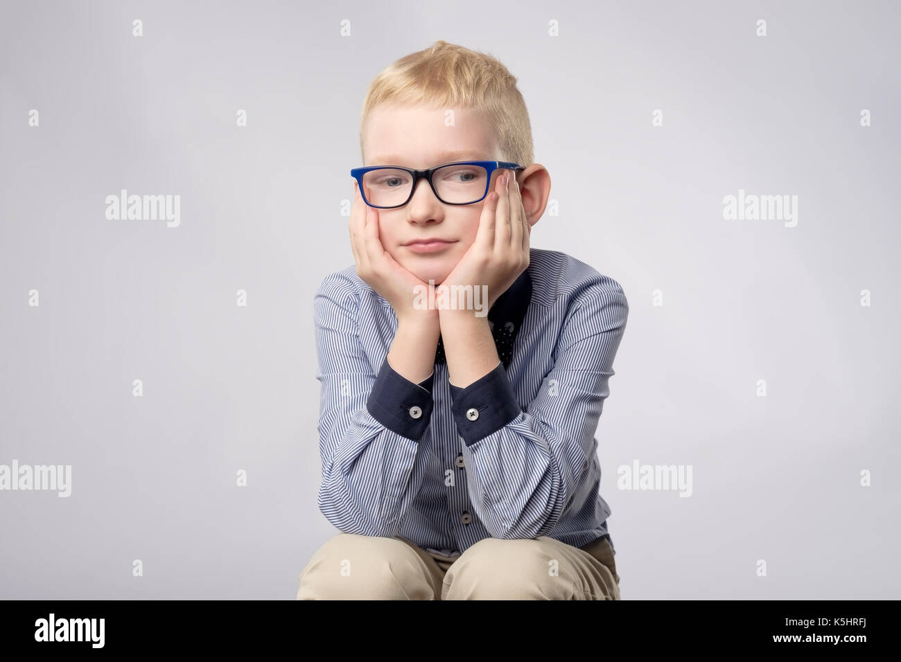 Portrait der kaukasischen blonde Junge in Gläsern mit gelangweilten Gesichtsausdruck in die Kamera auf weißem Hintergrund. Stockfoto