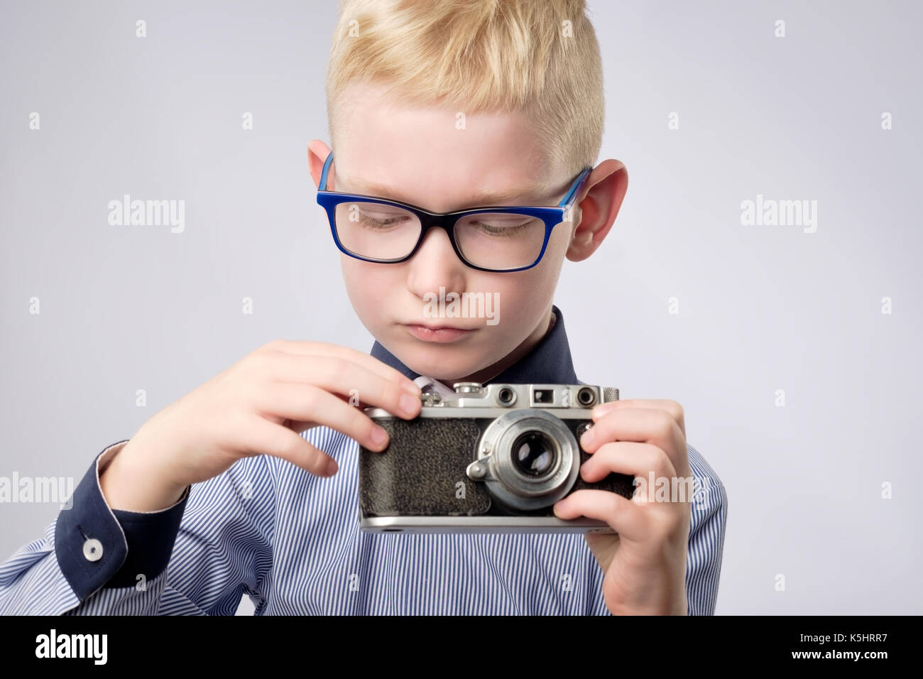 Fröhlich lächelnd Kind Junge Holding eine sofortige Kamera Stockfoto