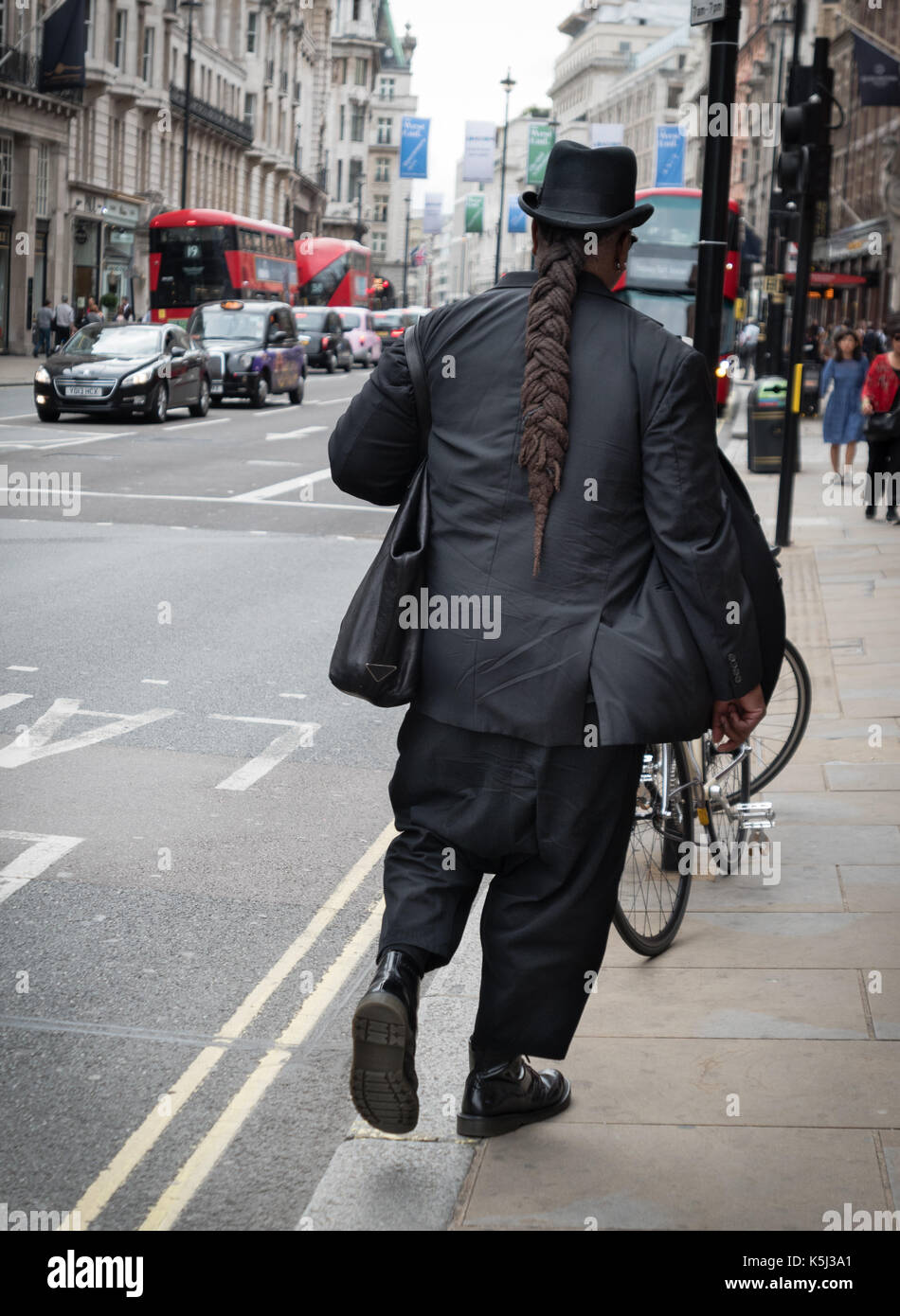 Ein Mann mit Zopf und Hut am Piccadilly, London, UK Stockfoto