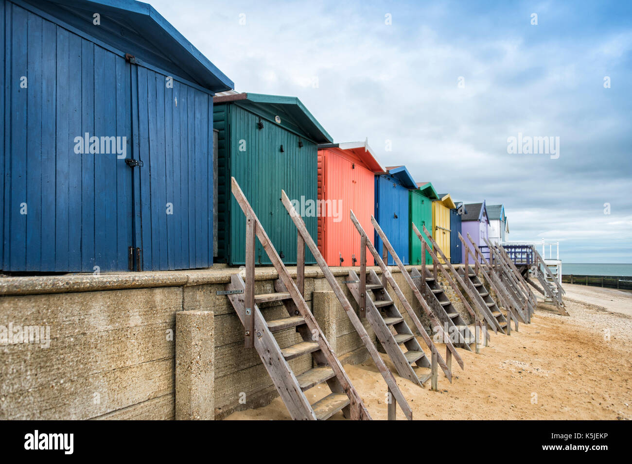 Zeile der hölzernen Umkleidekabinen am Strand an der Walton auf der Naze, Essex, Großbritannien Stockfoto