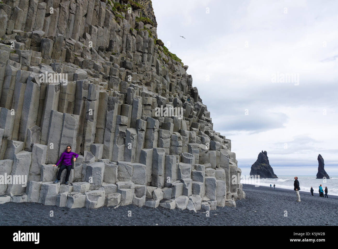 Basaltsäulen und Reynisdrangar Lavaseestacks am schwarzen Sandstrand von Reynisfjara in Island Stockfoto