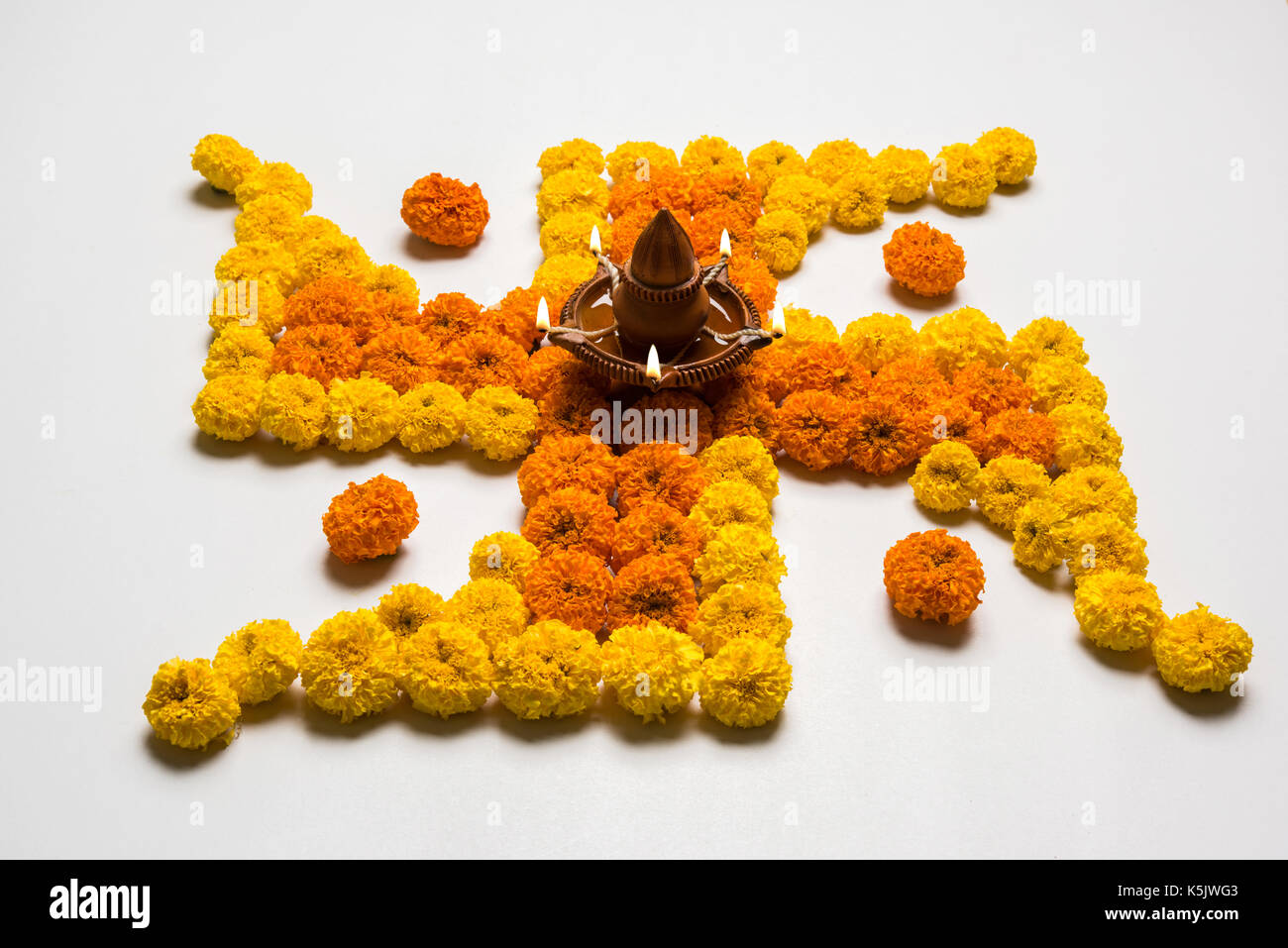 Hakenkreuz mit Marigold Blumen für Ugadi mit Clay Oil Lamp Stockfotografie  - Alamy