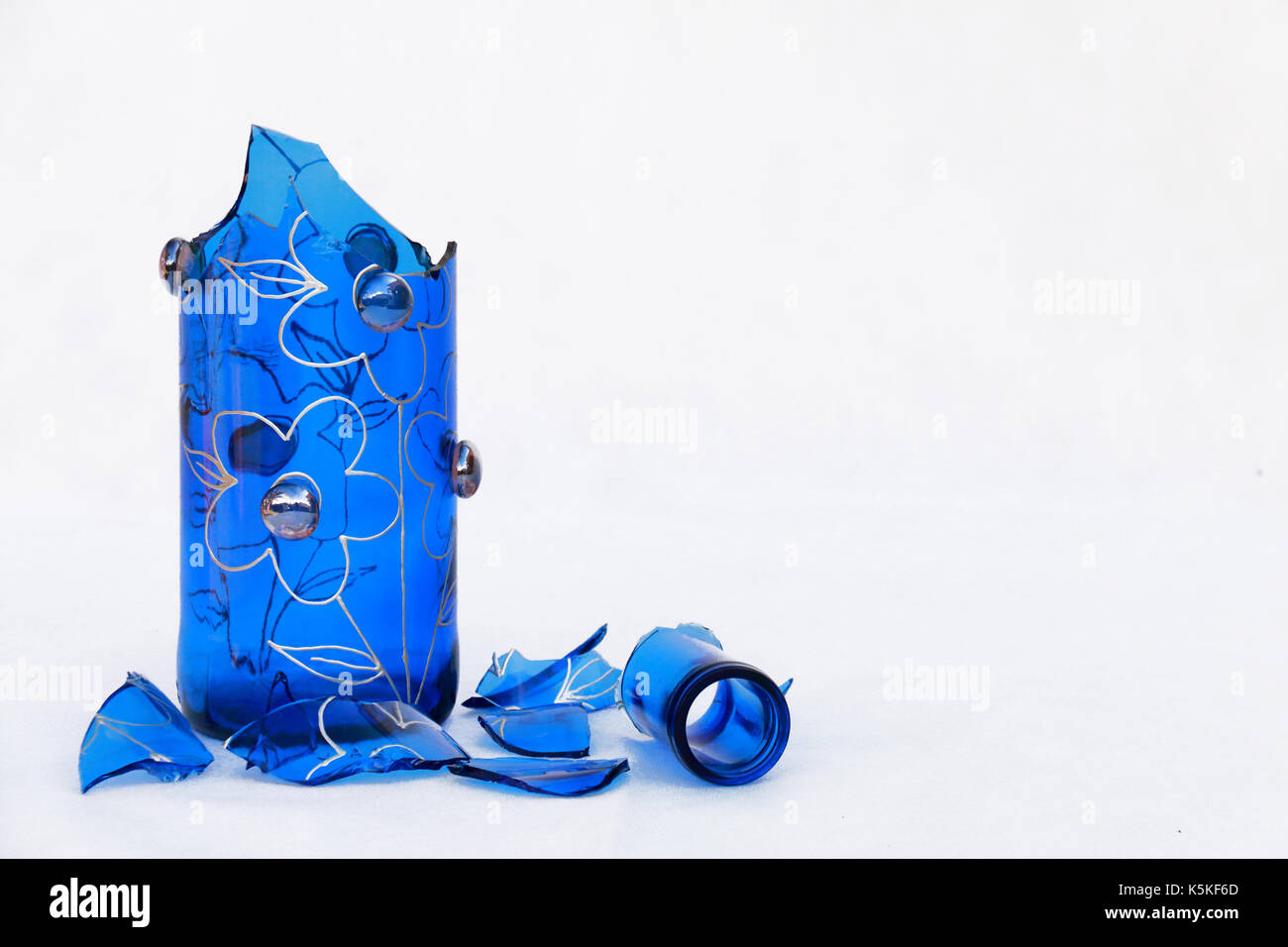 Kabelbruch im blauen Glasflasche, Seite Bild auf weißem Hintergrund Stockfoto