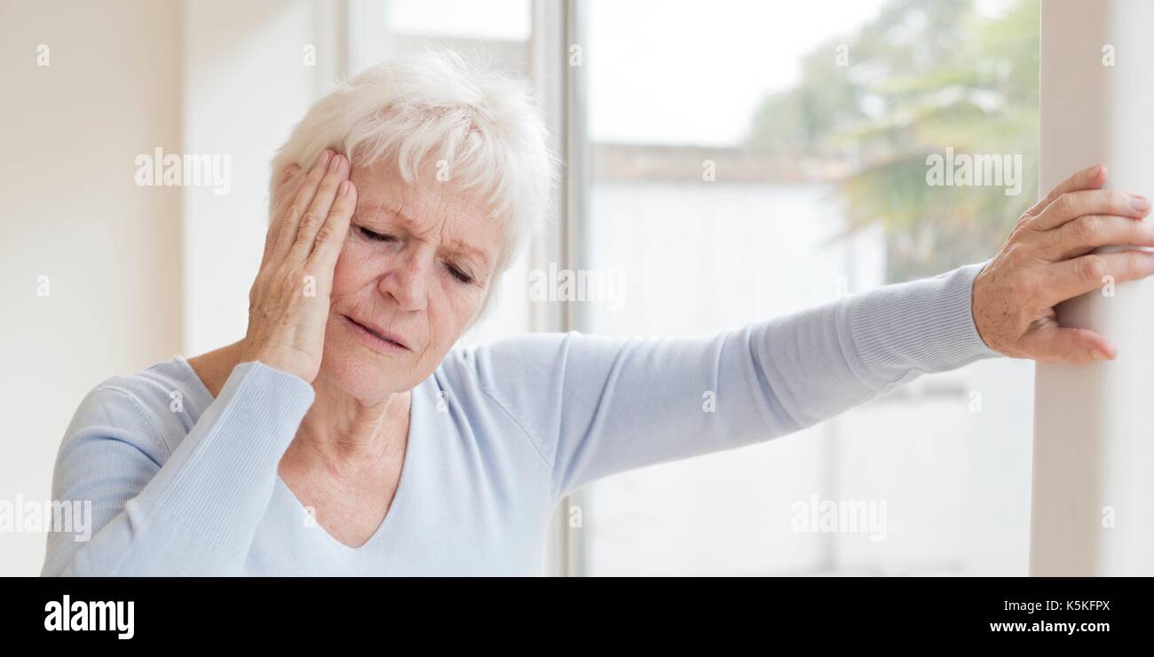 Ältere Frau mit Kopfschmerzen. Stockfoto
