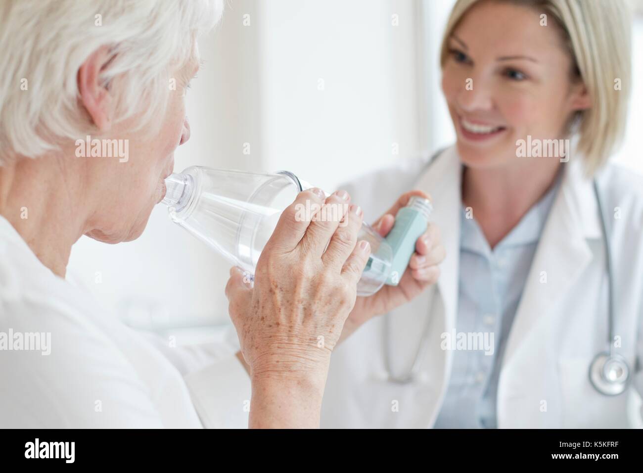 Ältere Frau mit Inhalator mit weiblichen Arzt zu beobachten. Stockfoto
