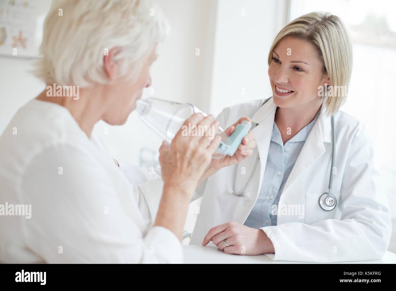 Ältere Frau mit Inhalator mit weiblichen Arzt zu beobachten. Stockfoto