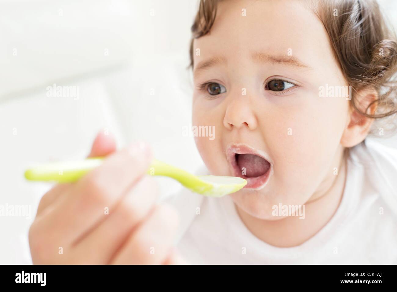 Weibliche toddler, Spoon Fed. Stockfoto
